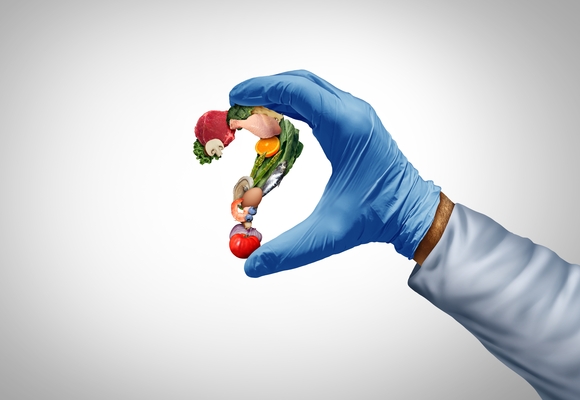 man with blue glove holding some food shaped like a question mark