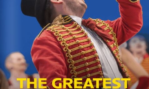 August magazine front cover a man in a red jacket singing into a mic, titled The Greatest Show